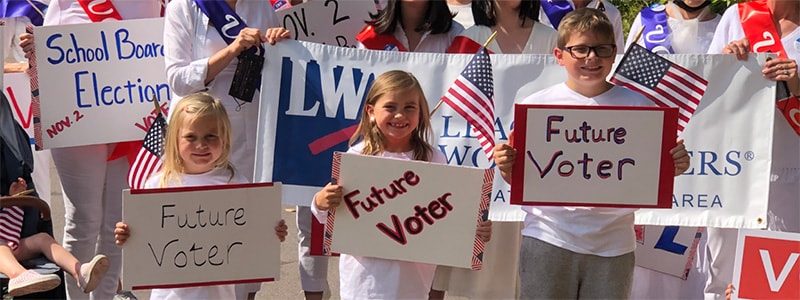 Children holding signs that say Future Voter.